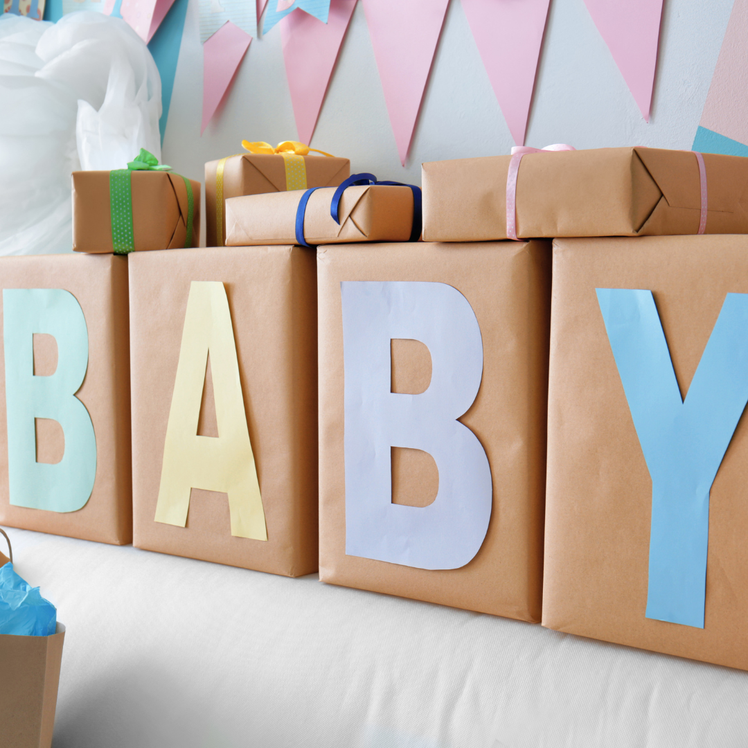 Wrapped baby shower gift boxes with letters spelling 'baby' on them. 